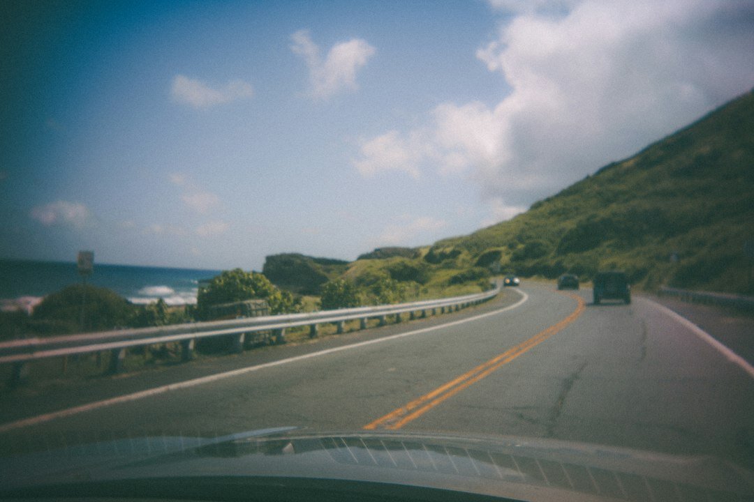 SUV driving along a tropical coastal road