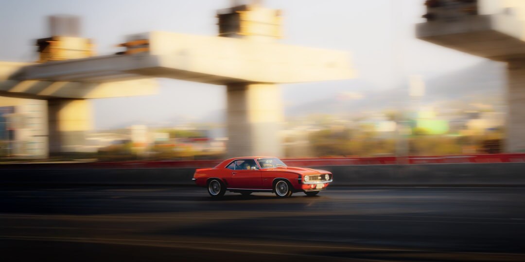 American muscle car driving on a highway at sunset